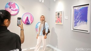 Pengunjung berfoto dengan karya yang dipamerkan di Astha District 8, Jakarta, Sabtu (4/10/2025). Pameran Brushstrokes of Hope ini menjadi wadah bagi seni untuk menyuarakan harapan, keberanian, serta solidaritas bagi penyintas kanker payudara dan komunitas di sekitarnya. Gerakan ini menjadi bentuk nyata kepedulian terhadap sesama melalui kekuatan kreativitas dan kolaborasi.