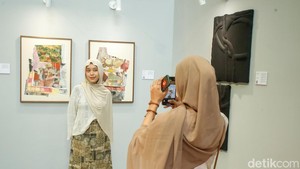 Pengunjung berfoto dengan karya dalam pameran Brushstrokes of Hope. Sejak 22 September 2025, Brushstrokes of Hope menampilkan rangkaian karya lukisan, patung, hingga mixed media dari seniman perempuan, talenta muda, dan para penyintas kanker payudara. Ada 12 nama yang terlibat, di antaranya Lala Bohang, Ruth Marbun, Naela Ali, hingga Yessiow.