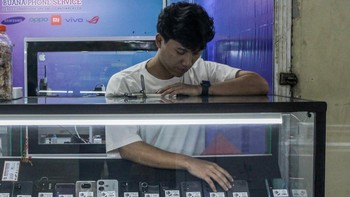 Pedagang merapihkan ponsel bekas yang dijual di ITC Roxy Mas, Jakarta, Minggu (5/10/2025). ANTARA FOTO/Naufal Khoirulloh