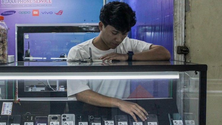 Pedagang ponsel bekas melayani calon pembeli di Pasar Poncol, Senen, Jakarta, Minggu (5/10/2025). Komdigi tegaskan wacana kebijakan blokir IMEI dalam transaksi jual beli ponsel bekas bukan untuk alih status dan dilakukan secara sukarela serta sebagai upaya melindungi konsumen dan menjaga keamanan ekosistem digital Indonesia. ANTARA FOTO/Naufal Khoirulloh