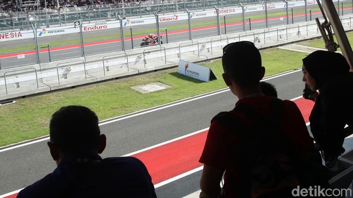 Suasana MotoGP Indonesia 2025 di Sirkuit Internasional Pertamina Mandalika, Lombok Tengah, Nusa Tenggara Barat, Minggu (5/10/2025), berlangsung penuh adrenalin dan sorak sorai penonton. Para pembalap saling bersaing ketat, memacu kecepatan maksimal di lintasan sepanjang sirkuit yang menantang.