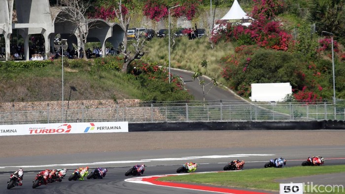 Suasana MotoGP Indonesia 2025 di Sirkuit Internasional Pertamina Mandalika, Lombok Tengah, Nusa Tenggara Barat, Minggu (5/10/2025), berlangsung penuh adrenalin dan sorak sorai penonton. Para pembalap saling bersaing ketat, memacu kecepatan maksimal di lintasan sepanjang sirkuit yang menantang.