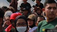 Sejumlah warga menyaksikan upacara HUT ke-80 TNI di kawasan Silang Monas, Jakarta, Minggu (5/10/2025). Sejak pagi, area Monas sudah dipenuhi masyarakat dari berbagai daerah yang datang membawa bendera Merah Putih dan mengenakan atribut bernuansa nasional.