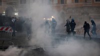 Aparat kepolisian yang mengenakan perlengkapan anti huru hara berupaya membubarkan massa menggunakan gas air mata.REUTERS/Yara Nardi