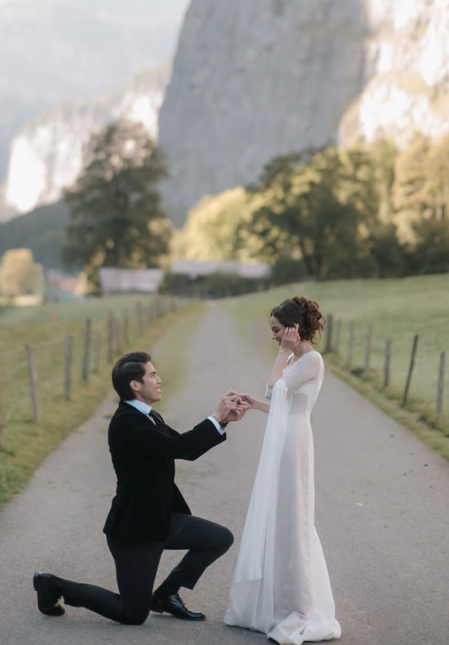 Dengan latar lembah hijau dan pegunungan berselimut salju, El Rumi terlihat berlutut di hadapan Syifa sambil memegang kotak cincin.  Foto: dok. Instagram @syifahadju