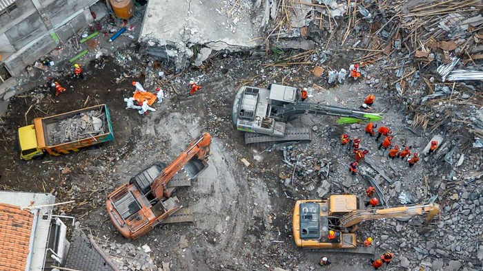 An aerial view shows rescuers searching for victims at the Al Khoziny Islamic boarding school in Sidoarjo, East Java, on October 5, 2025, after a multi-story building at the school collapsed during prayers, killing at least 37 people, with 26 others still missing, according to an official. (Photo by Dicky Bisinglasi / AFP)