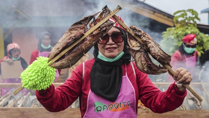 Seorang warga memperlihatkan ikan cakalang fufu saat mengikuti Festival Nyao Fufu di Kelurahan Dufa-Dufa Kampung Nelayan di Ternate, Maluku Utara, Senin (6/10/2025). Pemecahan rekor Museum Rekor Dunia Indonesia (MURI) dengan pengasapan sebanyak 6,62 ton ikan cakalang tersebut melibatkan sekitar 3.000 warga sebagai upaya untuk membantu peningkatan ekonomi lokal serta menjadi sarana pemasaran bagi pelaku UMKM di daerah itu. ANTARA FOTO/Andri Saputra
