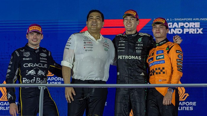 Winner George Russell of Great Britain and Mercedes AMG Petronas F1 Team, second Max Verstappen of the Netherlands and Oracle Red Bull Racing, and third Lando Norris of Great Britain and McLaren F1 Team stand on the podium at the Formula 1 Singapore Airlines Singapore Grand Prix in Marina Bay Street Circuit, Singapore, on October 5, 2025. (Photo by Robert Szaniszlo/NurPhoto via Getty Images)