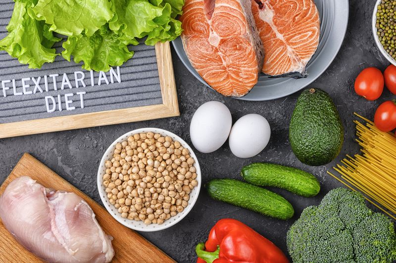 Ilustarsi diet flexitarian A set of products for a flexible diet. Salmon steak, chicken, chickpeas, mung beans and vegetables on a black background.