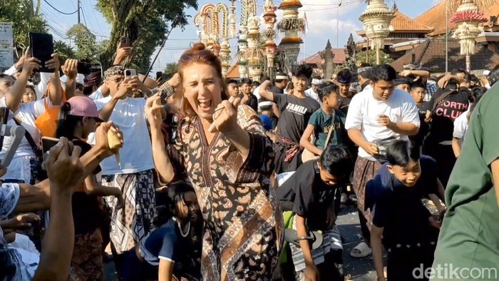 Keseruan warga dan bule-bule berbaur melemparkan ketupat ke udara saat tradisi Aci Tabuh Rah Pengangon, di Desa Kapal, Badung, Senin (6/10/2025). (Agus Eka)