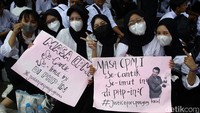Peserta aksi membawa spanduk bertuliskan berbagai tuntutan.