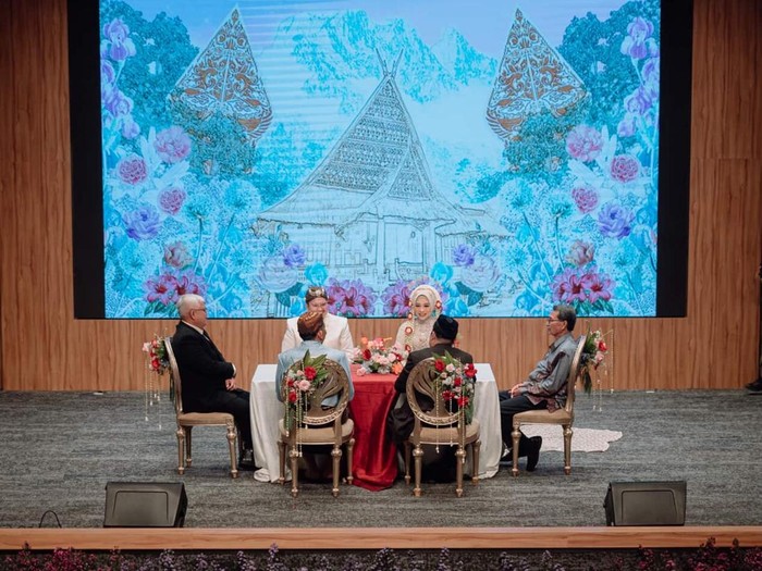Resepsi viral dengan konsep unik di gedung teater. Tamu undangan duduk nyaman serasa nonton drama. Intimate dan dramatis, memadukan modernitas venue dengan adat Jawa dan Mandailing.
