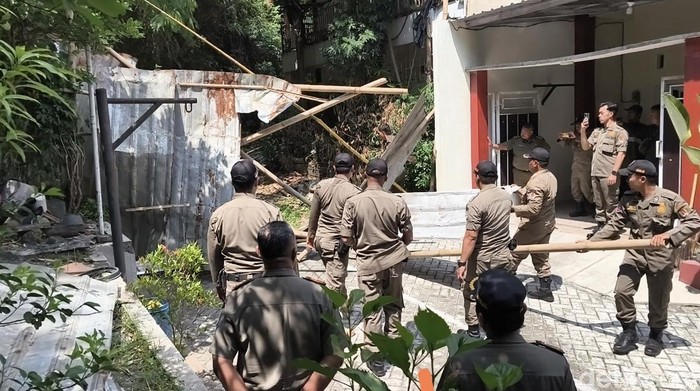 Petugas Satpol PP membongkar pagar seng di Jalan Sinar Mas VII, Perumahan Sinar Waluyo, Kelurahan Kedungmundu, Kecamatan Tembalang, Kota Semarang, Senin (6/10/2025).