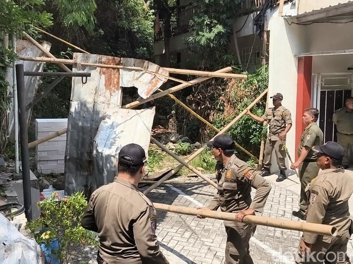Petugas Satpol PP membongkar pagar seng di Jalan Sinar Mas VII, Perumahan Sinar Waluyo, Kelurahan Kedungmundu, Kecamatan Tembalang, Kota Semarang, Senin (6/10/2025).