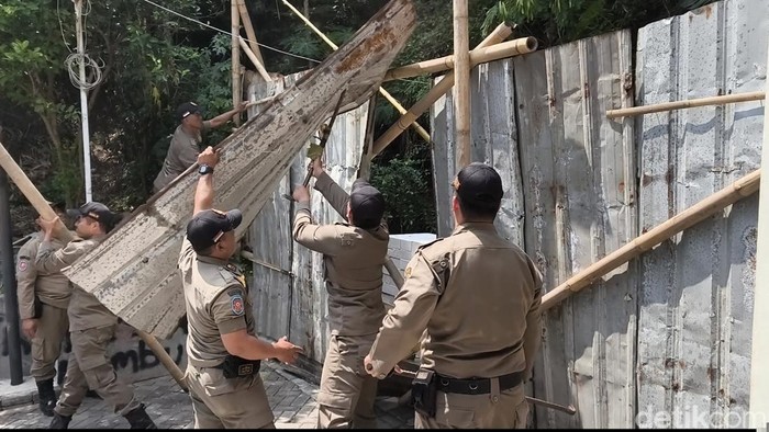 Petugas Satpol PP membongkar pagar seng di Jalan Sinar Mas VII, Perumahan Sinar Waluyo, Kelurahan Kedungmundu, Kecamatan Tembalang, Kota Semarang, Senin (6/10/2025).