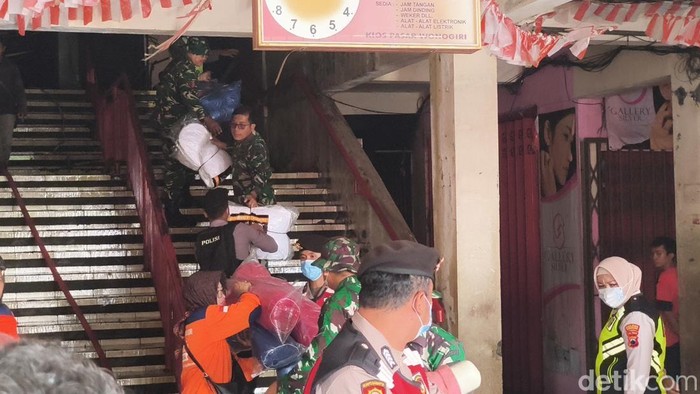 Petugas TNI Polri saat membantu proses evakuasi barang dagangan di Pasar Wonogiri yang terbakar, Senin (6/10/2025).