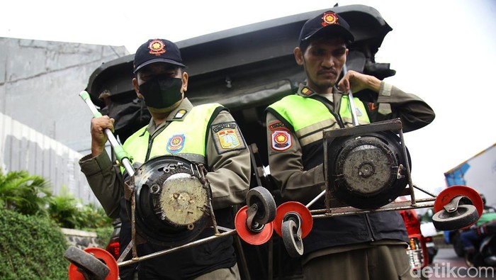Petugas Satuan Polisi Pamong Praja (Satpol PP) Kelurahan Bendungan Hilir (Benhil) kembali melakukan giat rutin menjaring ranjau paku di sepanjang Jalan Gatot Subroto, Jakarta, Senin (6/10/2025).