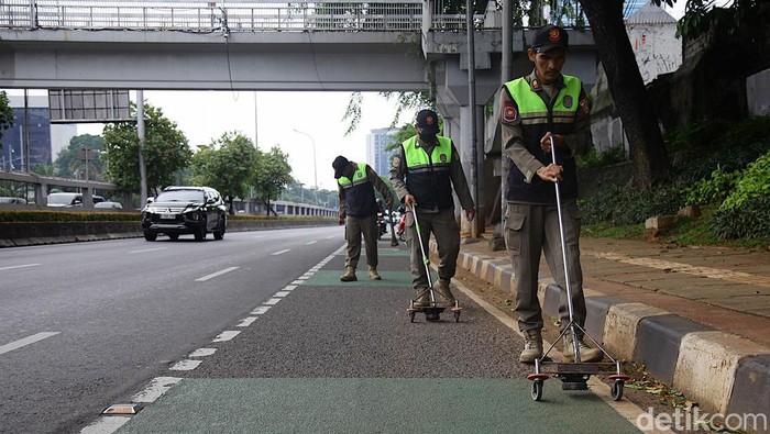 Petugas Satuan Polisi Pamong Praja (Satpol PP) Kelurahan Bendungan Hilir (Benhil) kembali melakukan giat rutin menjaring ranjau paku di sepanjang Jalan Gatot Subroto, Jakarta, Senin (6/10/2025).