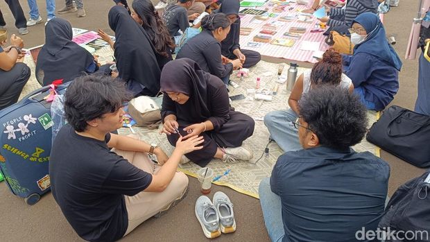 Sejumlah orang menggelar demonstrasi di depan Gedung MPR/DPR RI, Jakarta. Massa yang hadir membuat sejumlah kegiatan bertajuk 'piknik'. (Rizky AM/detikcom)