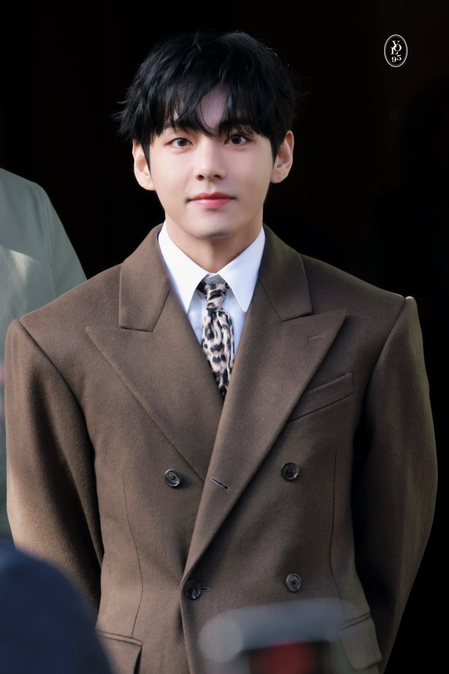 Idol yang digosipkan berpacaran dengan Jennie BLACKPINK itu tampil memukau dalam balutan kemeja putih berlapis coat panjang berwarna coklat. Dasi bermotif macan tutul CELINE seolah menjadi fashion statement V BTS. Foto: dok. Fansite V BTS