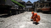 Dua anggota Basarnas menundukkan kepala dan membacakan doa di lokasi tragedi mushala Ponpes Al Khoziny, Sidoarjo, Selasa (7/10/2025). Momen haru itu menjadi simbol duka dan penghormatan terakhir bagi para korban. ANTARA FOTO/Umarul Faruq 