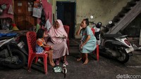 Sejumlah warga beraktivitas di depan rumah. Harga kebutuhan pokok yang terus meningkat membuat masyarakat kelas menengah bawah semakin berhati-hati dalam belanja.