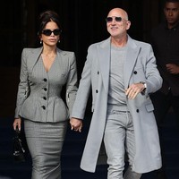 Pendiri Amazon itu tampil dengan kaus dan jeans yang dipadukan dengan coat abu-abu serta sneakers. Sedangkan Lauren Sanchez mengenakan setelan kotak-kotak vintage karya John Galliano tahun 1995. Setelan itu terdiri dari blazer peplum dan rok pensil. Foto: Getty Images/Neil Mockford