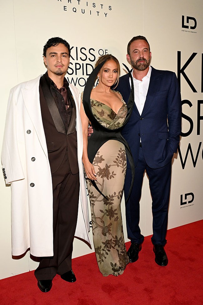 Jennifer tampil menawan dalam gaun cokelat bermotif bunga dengan lapisan hitam transparan yang menyerupai jaring laba-laba, sesuai tema filmnya. Sementara Ben memilih gaya klasik dalam setelan jas biru navy. Foto: Getty Images/Slaven Vlasic