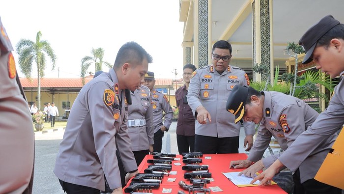 Kapolres Kampar AKBP Boby Ramadhan Putra Sebayang melakukan pengecekan senpi personel.