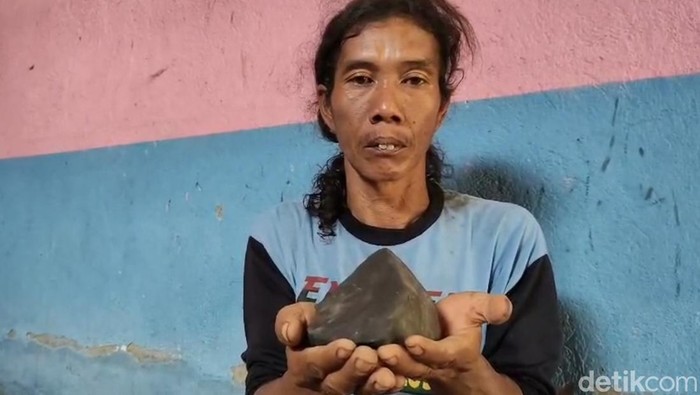 Warga Tegal, Masroni menunjukkan batu yang diduga meteor.