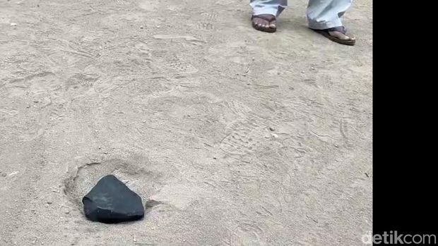 Penampakan batu hitam yang diduga meteor jatuh di pekarangan rumah Wasroni di Desa Jatilaba, Kecamatan Margasari, Tegal, Selasa (7/10/2025).