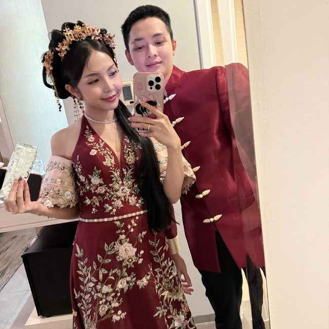 Meyden mengenakan cheongsam modern berwarna merah marun dengan detail bordir keemasan dan putih, berpadu dengan kain transparan di bagian lengan. Motif pada kain memperkuat nuansa tradisional Tiongkok. Sementara Hengky tampil dengan busana changshan khas Tiongkok. Foto: Instagram @btr_meyden