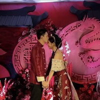 Untuk resepsi, Meyden dan Hengki memilih tema berbeda dengan gaya oriental. Keduanya serasi dalam balutan busana berwarna merah, senada dengan dekorasi di acara pernikahannya. Foto: Instagram @btr_meyden