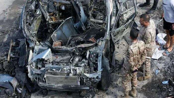 Lebanese security forces inspect a destroyed car targeted in an Israeli drone attack in the southern Lebanese village of Zebdine, on September 6, 2025. (AFP)
