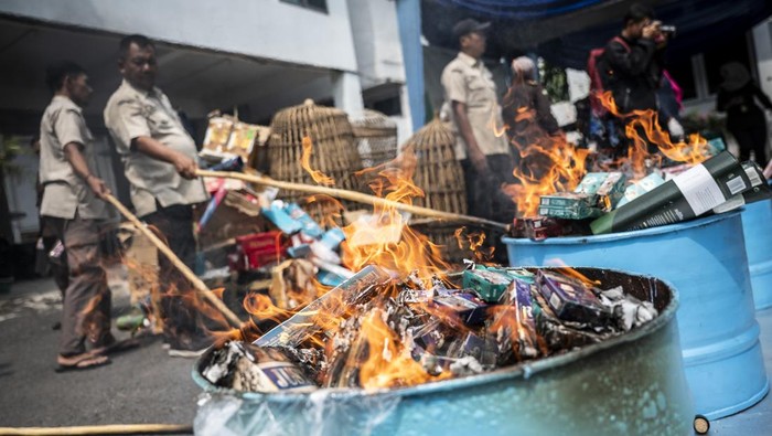 Petugas memusnahkan barang bukti rokok ilegal dalam rilis di halaman Kantor Kejaksaan Negeri Kota Semarang, Jawa Tengah, Selasa (7/10/2025). Kejaksaan Negeri Kota Semarang memusnahkan barang bukti dari 97 perkara, berupa 19.496 botol minuman keras, 32 unit gawai, 13 senjata tajam, 76 koli dan 86 karton rokok ilegal, serta narkotika dan psikotropika. ANTARA FOTO/Aprillio Akbar/nz
