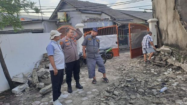 Polisi mengecek tembok ambruk yang menimpa motor-motor diparkir di Jombang, Ciputat, Selasa (7/10/2025).