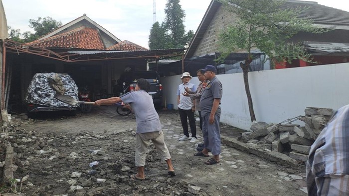 Polisi mengecek tembok ambruk yang menimpa motor-motor diparkir di Jombang, Ciputat, Selasa (7/10/2025).