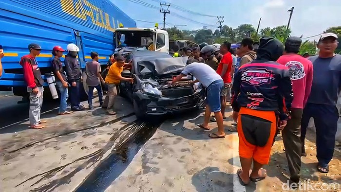 Sejumlah warga membantu mengevakuasi mobil yang ringsek setelah tertabrak truk di Jalan Raya Sukabumi - Bogor, tanjakan Pamuruyan, Kecamatan Cibadak. Tabrakan beruntun terjadi sekitar pukul 09.50 WIB.