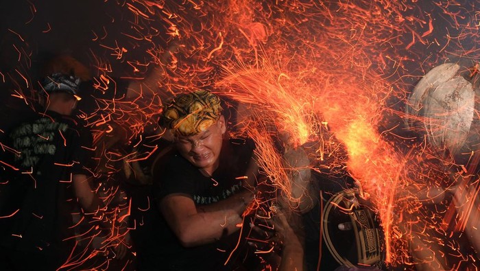 Sejumlah pemuda saling memukulkan bara api dari sabut kelapa saat tradisi mesiat geni atau perang api di Desa Tuban, Badung, Bali, Senin (6/10/2025). Tradisi tahunan tersebut diikuti puluhan pemuda untuk menyucikan alam dan melebur hal negatif serta memohon keharmonisan semesta. ANTARA FOTO/Nyoman Hendra Wibowo