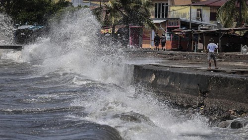 Seorang warga menghindari empasan gelombang tinggi yang menghempas ke batu pemecah ombak di Bastiong Ternate, Maluku Utara, Selasa (7/10/2025). BMKG Stasiun Meteorologi Kelas I Sultan Baabullah Ternate mengeluarkan peringatan dini cuaca ekstrem yang mencakup gelombang tinggi mencapai 2,2 meter di perairan sekitar Maluku Utara dan warga  yang tinggal di wilayah pesisir agar tetap waspada menghadapi potensi cuaca ekstrem yang dapat memicu gelombang tinggi.ANTARA FOTO/Andri Saputra