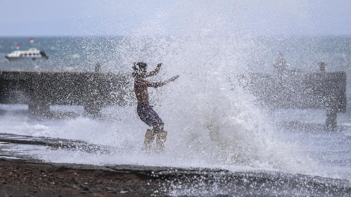 Seorang warga menghindari empasan gelombang tinggi yang menghempas ke batu pemecah ombak di Bastiong Ternate, Maluku Utara, Selasa (7/10/2025). BMKG Stasiun Meteorologi Kelas I Sultan Baabullah Ternate mengeluarkan peringatan dini cuaca ekstrem yang mencakup gelombang tinggi mencapai 2,2 meter di perairan sekitar Maluku Utara dan warga  yang tinggal di wilayah pesisir agar tetap waspada menghadapi potensi cuaca ekstrem yang dapat memicu gelombang tinggi.ANTARA FOTO/Andri Saputra