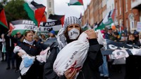 Seorang demonstran mengenakan topeng bertuliskan 2 tahun untuk mendukung warga Palestina dalam protes nasional di Dublin, Irlandia. Operasi militer Pasukan Pertahanan Israel (IDF) telah menewaskan sedikitnya 66.000 orang, sekitar 80% di antaranya warga sipil, dan melukai sekitar 169.000 orang, menurut estimasi konservatif dari Kementerian Kesehatan Gaza yang dikelola Hamas. Lembaga internasional memperkirakan jumlah korban sebenarnya jauh lebih tinggi. Foto: REUTERS/Clodagh Kilcoyne