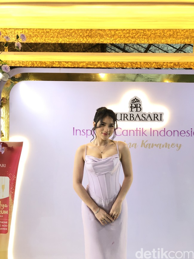 Untuk tatanan rambut, ia memilih gaya sanggul modern yang sedikit longgar (messy updo), dengan beberapa helai rambut dibiarkan jatuh membingkai wajah, menciptakan kesan manis, anggun, dan feminin. Kulitnya terlihat flawless dengan complexion yang merata dan blush on lembut berwarna peach atau pink yang memberi rona sehat pada pipi. Bagian bibir dipoles dengan lipstik berwarna nude atau pink yang natural, menyeimbangkan fokus wajah. Foto: Gresnia/Wolipop.