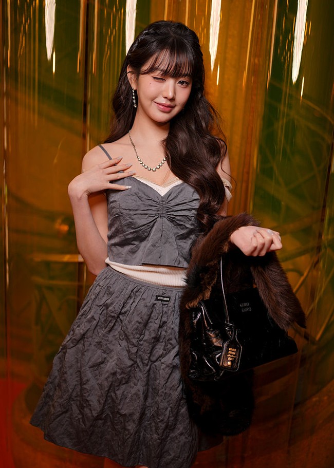 Setelah menampilkan gaya klasik di Paris Fashion Week tahun lalu, kini Jang Wonyoung IVE terlihat chic dan edgy sebagai “Princess Miu Miu” dengan crop top dan mini skirt biru beraksen kerutan. Gayanya dilengkapi dengan loafers dan kaos kaki senada berwarna hitam. Foto: Getty Images