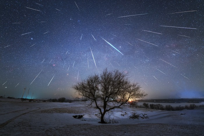 First place in the 2021 IAU OAE Astrophotography Contest, category Meteor showers: Geminid Meteor Shower from China, by Dai Jianfeng, China. A meteor shower occurs when the Earth in its orbit around the Sun, passes through a debris trail left previously by a comet on its approach around the Sun. As the Earth enters this debris (small sand grain sized), they enter the atmosphere at high speeds and on parallel trajectories, burning completely leaving beautiful tracks (streaks) in the sky. These streaks can appear and disappear in the blink of an eye, or last much longer. On rare occasions the debris originates from asteroids, as in the case of the Geminid meteor shower, shown in this image, picturing many streaks of debris captured in the sky of China in 2017. Due to relative motions and perspective, the shower appears to come from one single point, known as the radiant point, beautifully pictured in this image. This is similar to driving in a car on a rainy day without any wind, looking out the front window it seems that the rain is coming directly towards the window, when in fact the rain is falling vertically downwards. Link:  See image in Zenodo