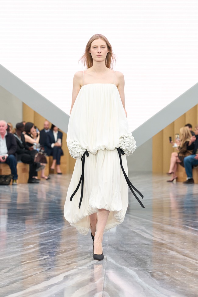 Gaun-gaun longgar dengan garis vertikal bersanding dengan potongan struktural yang tajam, sementara topi dan aksesori tampak seperti “implosi bentuk”, mencerminkan gagasan tentang restrukturisasi dan kebebasan diri. (Foto: Dok. Dior)