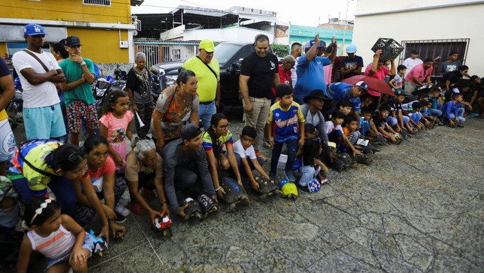 Lomba Kura-Kura Lukis di Venezuela Gaungkan Cinta Alam Children hold Morrocoyes, terrestrial tortoises native to South America, during a tortoise race held to celebrate the upcoming feast day of Saint Francis of Assisi, the patron saint of animals, in the town of San Francisco de Asis, Venezuela, October 3, 2025. REUTERS/Juan Carlos Hernandez