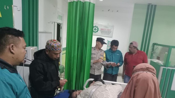 Polisi saat melihat jasad korban di rumah sakit.