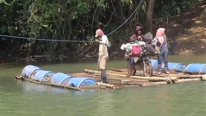Warga di Pesisir Barat saat melintasi sungai dengan rakit seadanya imbas jembatan ambruk.