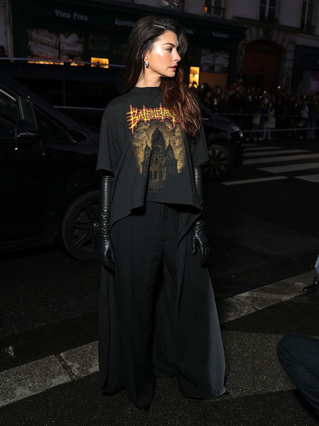 Untuk melengkapi penampilan, wanita 42 tahun ini memadukannya dengan celana panjang hitam, sarung tangan kulit, dan sepatu runcing yang menambah kesan tajam pada keseluruhan busana. Foto: Getty Images for Balenciaga/Arnold Jerocki